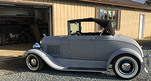 An old hot rod being driven into the DeCoste Designs shop.