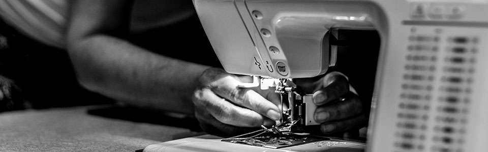 Hands doing delicate sewing work.